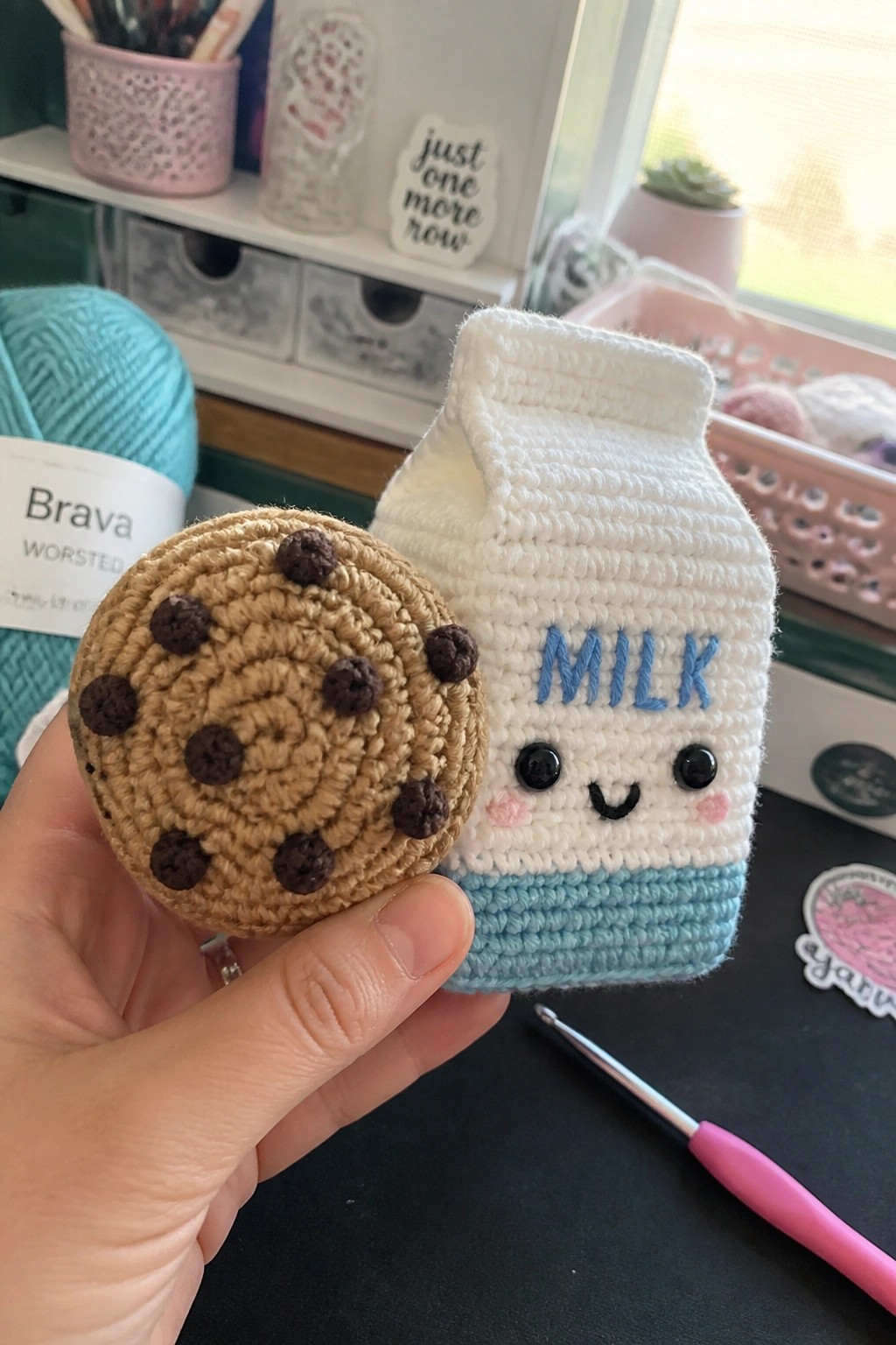 Hand holding crocheted cookie and smiling milk carton with blue base