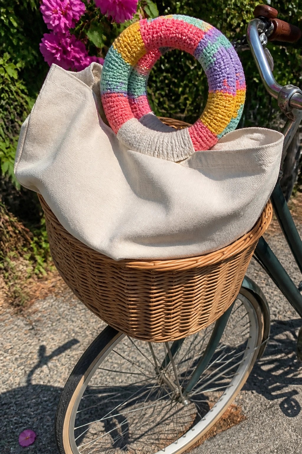 Beige canvas tote with rainbow ring handle in wicker bicycle basket