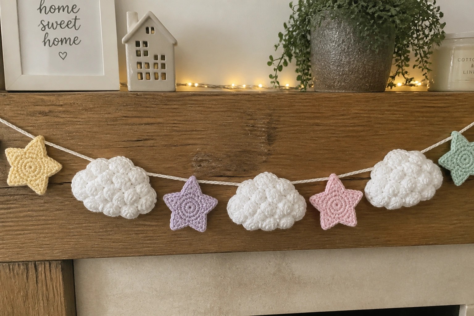 Crocheted white clouds and colorful stars garland on wooden fireplace mantel