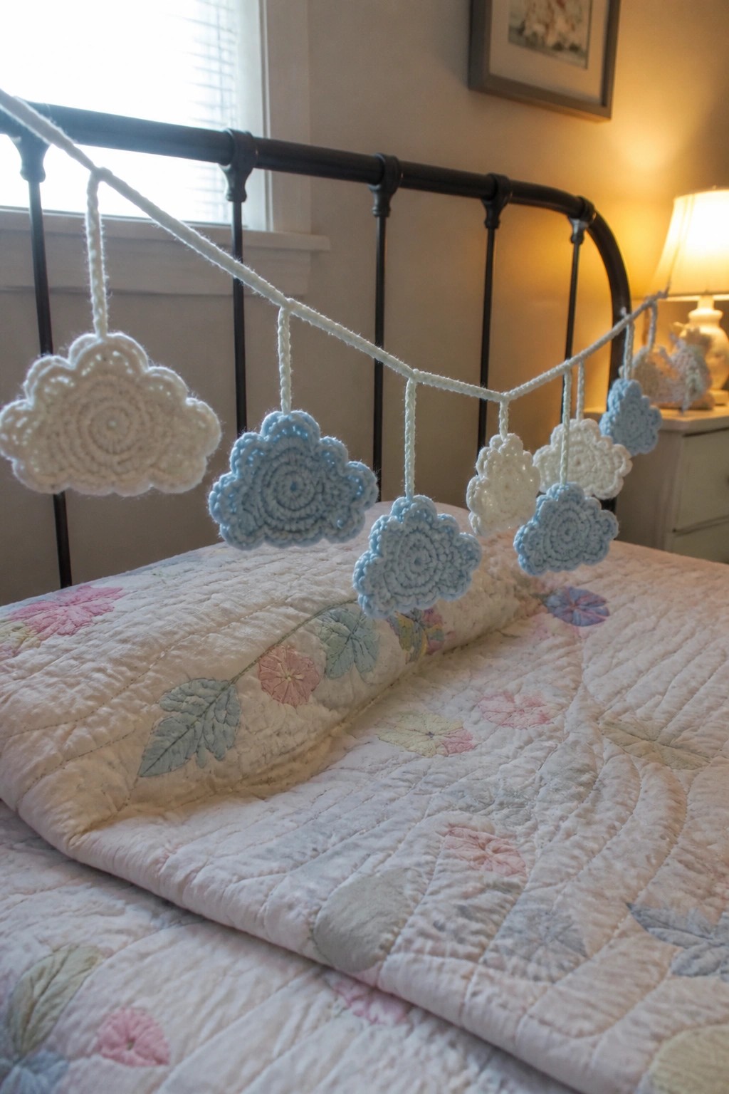 White and blue crocheted cloud garland on black metal bed with floral quilt