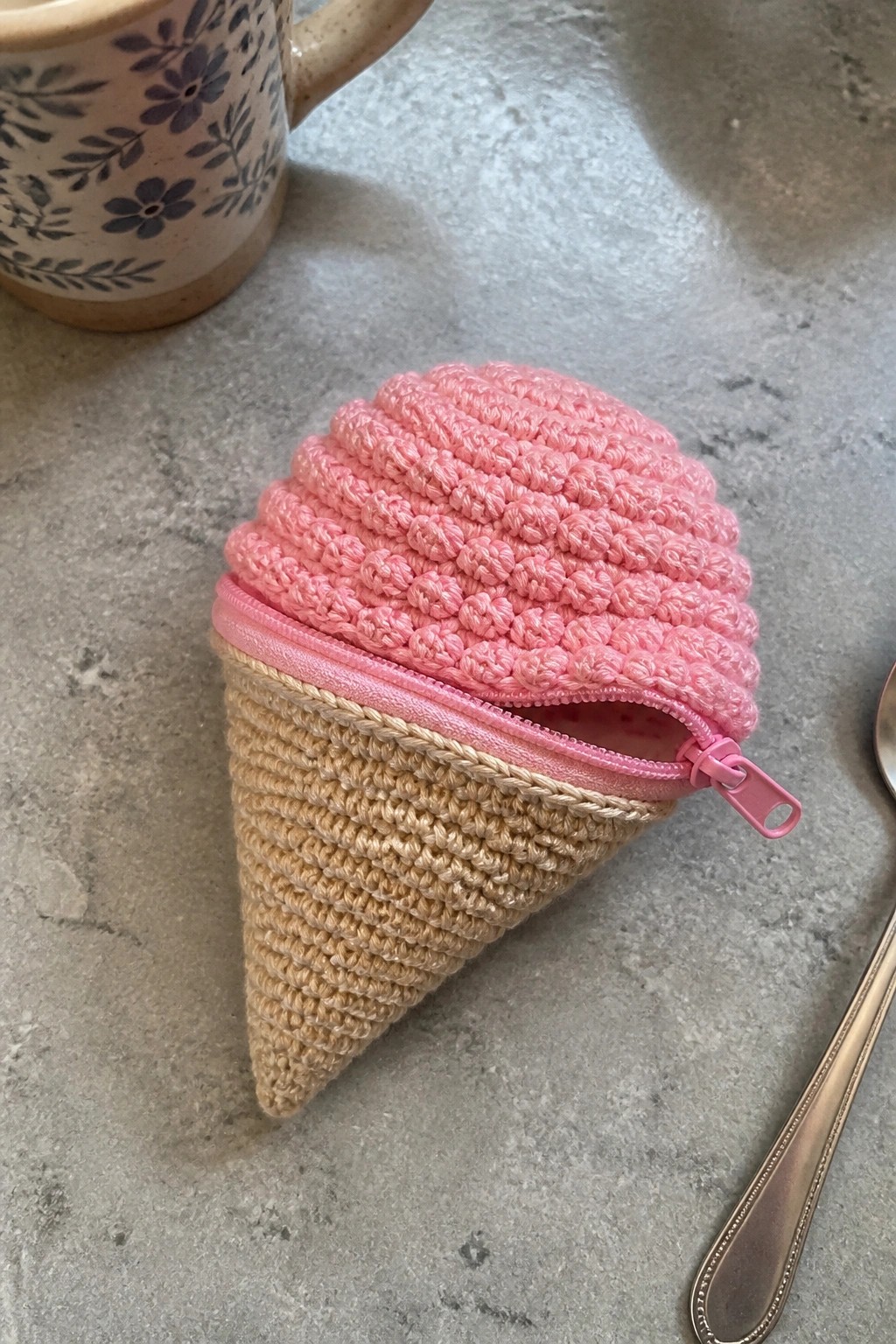 Pink crocheted ice cream cone pouch with beige base and pink zipper